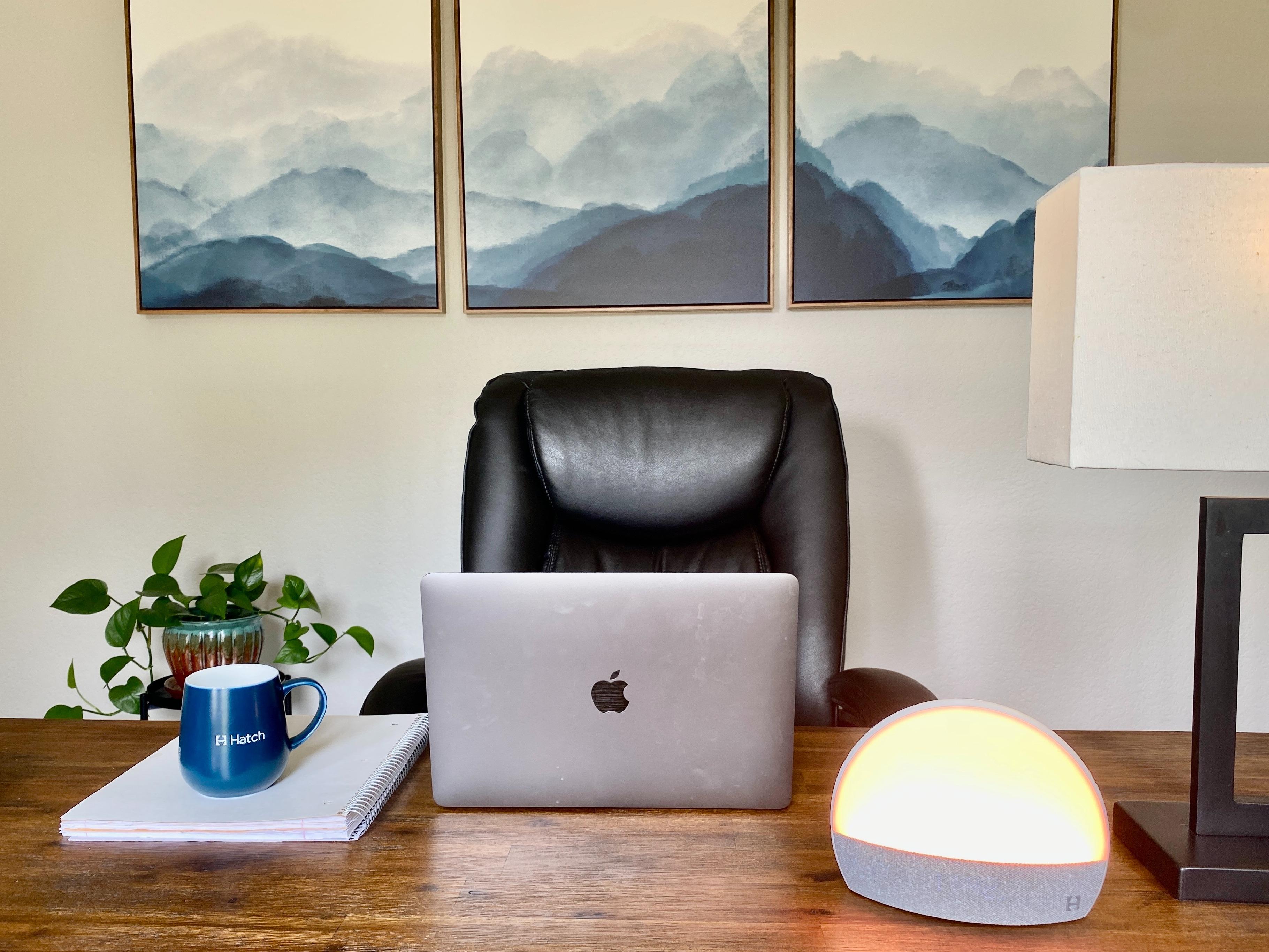 A Macbook sitting on a desk next to a Hatch Restore