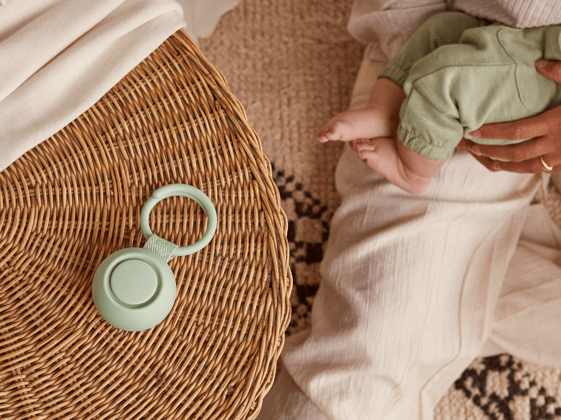 Hatch Go mint colorway sitting on a nursery table while a mother holds her baby